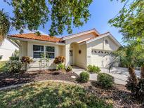 Charming single-story home with terra cotta tile roof, manicured landscaping, and attached two car garage at 4885 Tamarack Trl, Venice, FL 34293