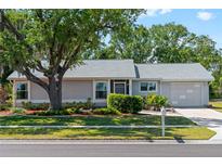 Charming single-story home with a well-manicured front yard, mature landscaping, and attached garage at 5457 Talbrook Rd, North Port, FL 34287