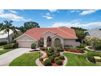Charming single Gathering home featuring a lush landscaped yard and a classic red tile roof at 6507 Drewry'S Blf, Bradenton, FL 34203
