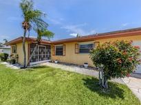 Charming home with a well-maintained lawn, tropical plants, and decorative shutters at 1320 Whispering Ln, Venice, FL 34285