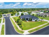 Landscaped lawn of this home has tropical plants and mature trees, presenting great curb appeal at 2000 Jasmine Way, North Port, FL 34287
