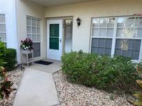 Inviting front entrance with a decorative planter, manicured landscaping, and a well-lit doorway at 406 Laurel Lake Dr # 103, Venice, FL 34292