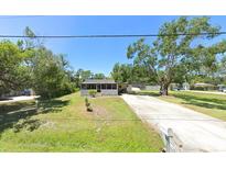 Charming single-story home with a well-maintained lawn and a long driveway at 5106 S Lockwood Ridge Rd, Sarasota, FL 34231