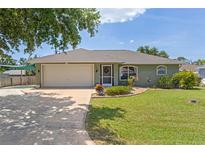 Charming home featuring an attached two car garage, lush lawn, and inviting front entrance at 5264 Albion Rd, Venice, FL 34293