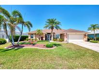 Charming single-story home boasts lush landscaping, palm trees, and a well-maintained lawn at 5868 Jefferson Rd, Venice, FL 34293
