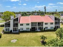 Well-maintained condo building features clean lines, lush lawn, and a distinctive red roof, embodying comfort and style at 770 Village Cir # 232, Venice, FL 34292