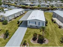 Charming single-story home with a covered carport, well-maintained lawn, and waterway views at 798 Fairmount Dr, North Port, FL 34287