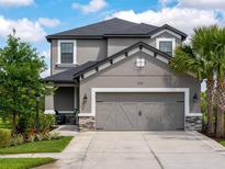 Charming two-story home featuring a spacious two-car garage, palm tree, and beautifully landscaped front yard at 8304 Shooting Star Rd, Sarasota, FL 34241