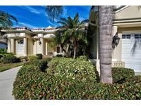 Charming home featuring well-maintained landscaping, mature palms, and a welcoming front entrance with beautiful architectural details at 1037 Beckley Cir, Venice, FL 34292