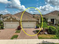 Beautiful single-story home with a tile roof, lush landscaping and a brick driveway, located in a desirable community at 11648 Okaloosa Dr, Venice, FL 34293