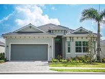Charming single-story home features a gray exterior, well-manicured lawn, and a two-car garage at 12548 Wellen Golf St, Venice, FL 34293