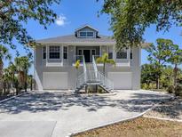 Charming coastal home with a two-story entrance, a dual garage, and lush tropical landscaping at 13314 Prentice Ave, Port Charlotte, FL 33953