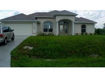 Charming one-story home featuring an attached garage and covered entryway with landscaped front yard at 1450 Yakutat Rd, North Port, FL 34287