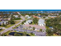 Beautiful aerial view of the condo complex with lush landscaping, community pond, and Gulf views at 1730 Manasota Beach Rd # 212, Englewood, FL 34223