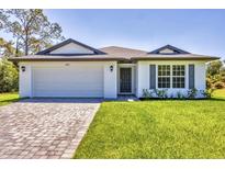 Beautiful single-story home featuring a neatly paved driveway and a well-manicured lawn at 2032 Jagust Rd, North Port, FL 34288