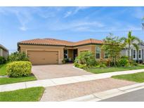 Charming single-story home featuring a paver driveway, well-manicured lawn, and lush landscaping at 20660 Ovid Ln, Venice, FL 34293