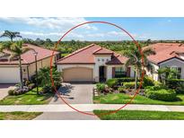 Charming single-story home with a red tile roof, lush landscaping, and a two-car garage at 23493 Copperleaf Dr, Venice, FL 34293