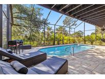 Enclosed pool with brick pavers, lounge chairs, and view of lush landscaping at 236 Cory St, Port Charlotte, FL 33953