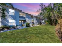 Low angle of a two-story condo with lawn, showing walkways and staircases at 2614 River Preserve Ct # 2614, Bradenton, FL 34208