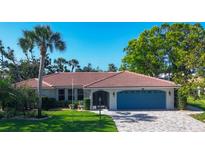Charming single-story home with a well-manicured lawn, blue garage door, and a brick driveway at 316 Signorelli Dr, Nokomis, FL 34275