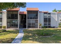 Condo building featuring multiple units with balconies and a well-maintained lawn and landscape at 3255 Beneva Rd # 102, Sarasota, FL 34232
