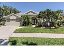 Beautiful single-story home with mature landscaping, manicured lawn, and an attached two-car garage at 396 Lansbrook Dr, Venice, FL 34292