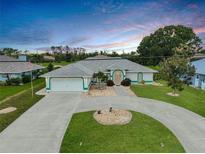 Charming single-story home featuring a circular driveway, lush landscaping, and a two-car garage, perfect for suburban living at 447 Rotonda Cir, Rotonda West, FL 33947