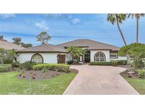Charming one-story home with a tile roof, mature landscaping, and a brick driveway at 4532 Chase Oaks Dr, Sarasota, FL 34241