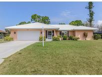 Charming single-story home with a white tile roof, lush lawn, and inviting curb appeal at 455 Rubens E Dr, Nokomis, FL 34275