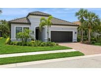 Beautiful single Gathering home with a tile roof, paver driveway, manicured lawn and tropical landscaping at 5581 Piccolo St, Nokomis, FL 34275
