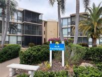 Exterior view of the Sandpiper condos with palm trees and lush landscaping at 618 Bird Bay S Dr # 212, Venice, FL 34285