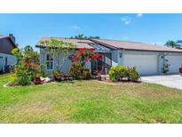 Charming home with lush landscaping, colorful flowers, and a well-maintained lawn at 657 Foxwood Blvd, Englewood, FL 34223