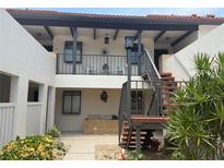 Exterior shot of a two-story building with plants and stairs at 744 Avenida Estancia # 142, Venice, FL 34292