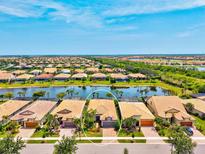 Beautiful aerial view of single-Gathering homes, landscaped yards, and waterfront in a residential neighborhood at 13873 Karina St, Venice, FL 34293
