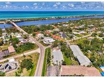 Beautiful aerial view of coastal neighborhood featuring waterfront homes and vibrant blue ocean at 1730 Manasota Beach Rd # 215, Englewood, FL 34223