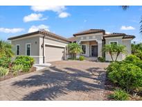 Elegant single-story home featuring a tile roof, paver driveway, attached two-car garage, and well-maintained landscaping at 329 Myrtle Ave, Nokomis, FL 34275