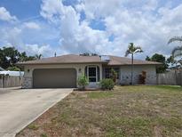 Charming single-story home featuring an attached garage, well-maintained lawn, and inviting front entrance at 3311 Papaya Rd, Venice, FL 34293