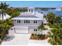 Stunning waterfront home features a rooftop terrace, spacious garage, and lush landscaping at 3516 Casey Key Rd, Nokomis, FL 34275