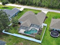 Aerial view of screened-in pool with patio area and fully fenced yard at 4103 Kinlock St, North Port, FL 34286