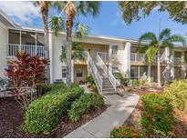 Inviting condo exterior featuring lush landscaping and screened balconies, a tropical oasis at 421 Cerromar Ter # 471, Venice, FL 34293