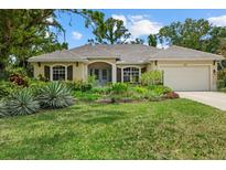 Charming home with lush landscaping, a well-maintained lawn, and a welcoming facade at 427 Autumn Chase Dr, Venice, FL 34292