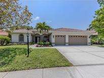Charming single-story home boasts a tile roof, well-manicured lawn, and a spacious three-car garage at 463 Park Trace Blvd, Osprey, FL 34229