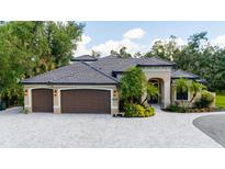 Stunning single-story home featuring a three-car garage, beautiful landscaping, and a paver driveway at 5850 Saddle Oak Trl, Sarasota, FL 34241