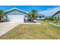 Charming blue single-story home with well-maintained landscaping and a two-car garage at 5872 Monroe Rd, Venice, FL 34293