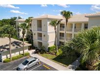 Beautiful condo building with lush tropical landscaping, a parking lot, and private balconies in a sunny, inviting setting at 600 Gardens Edge Dr # 613, Venice, FL 34285
