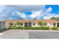 Low-rise condo complex with manicured landscaping, shrubbery, and private parking, inviting curb appeal at 6796 Gasparilla Pines Blvd # 18, Englewood, FL 34224