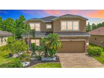 Two-story home featuring a beautifully landscaped front yard and a brick-paved driveway leading to a two-car garage at 9019 39Th Street Cir E, Parrish, FL 34219