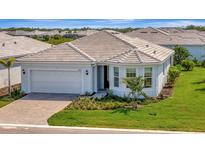Charming single-story home features a well-manicured lawn and attached two-car garage at 10121 Beachwalk Dr, Englewood, FL 34223