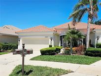 Charming single-story home features a tile roof, manicured landscaping, and a two-car garage at 10930 Lerwick Cir, Englewood, FL 34223
