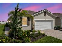 Charming single-story home featuring a well-manicured lawn and a two-car garage with brick paved drive at 12538 Somatic Ct, Venice, FL 34293